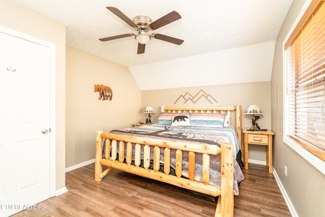 bedroom featuring ceiling fan, hardwood / wood-style flooring, a textured ceiling, and lofted ceiling