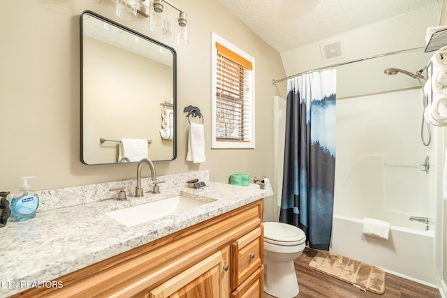 full bathroom featuring toilet, vanity, wood-type flooring, shower / tub combo, and a textured ceiling