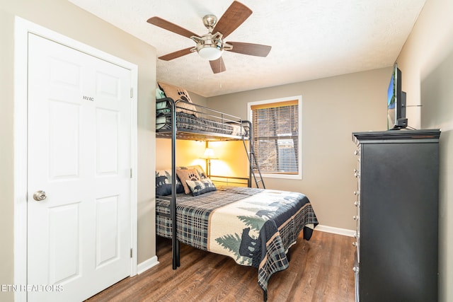 bedroom featuring ceiling fan, dark hardwood / wood-style floors, and a textured ceiling