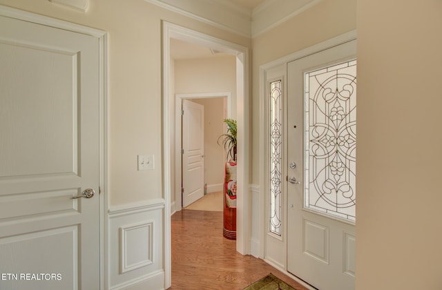 entryway featuring light wood-type flooring and crown molding