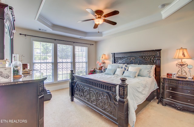 bedroom featuring crown molding, light carpet, a raised ceiling, and ceiling fan