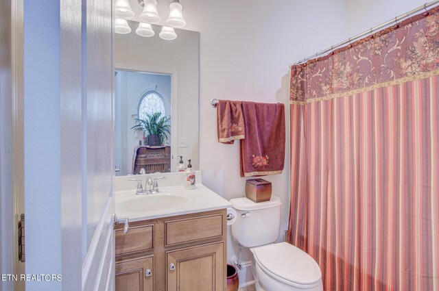 bathroom featuring toilet, a shower with curtain, and vanity