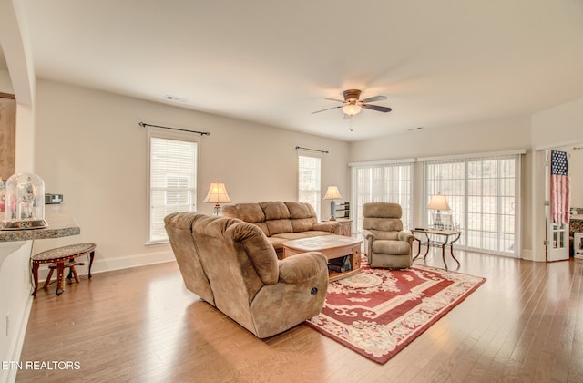 living room featuring hardwood / wood-style floors and ceiling fan