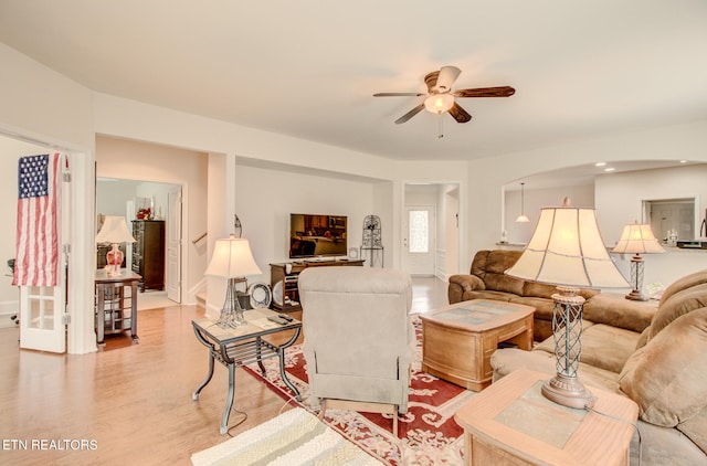 living room with ceiling fan and light hardwood / wood-style flooring