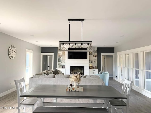 dining room with built in features, hardwood / wood-style floors, and a fireplace