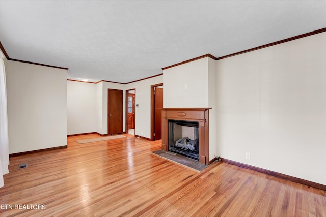 unfurnished living room with a fireplace with flush hearth, light wood-type flooring, a textured ceiling, and baseboards