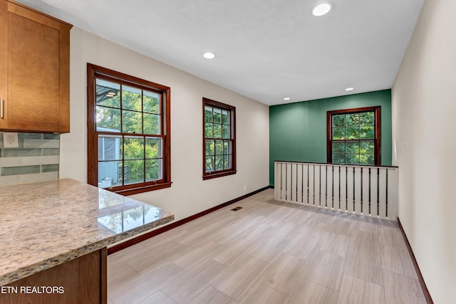 unfurnished room with plenty of natural light, baseboards, and recessed lighting