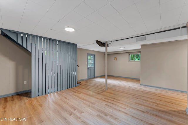 unfurnished room featuring wood finished floors, visible vents, and baseboards