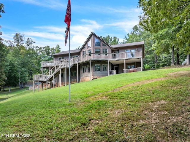 back of property featuring a wooden deck and a yard