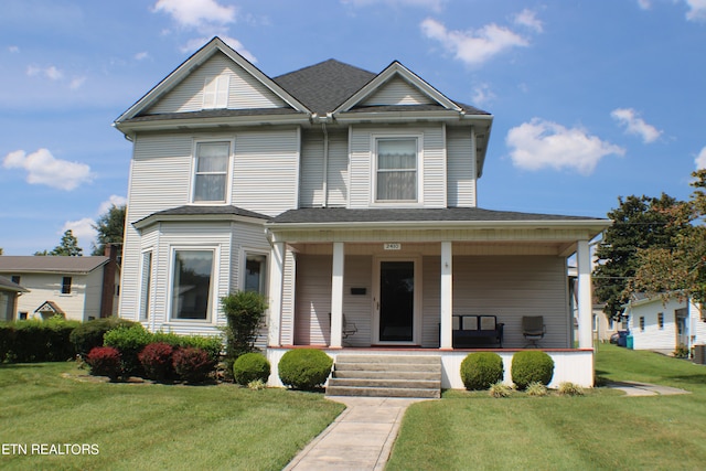 view of front of house featuring covered porch, cooling unit, and a front yard