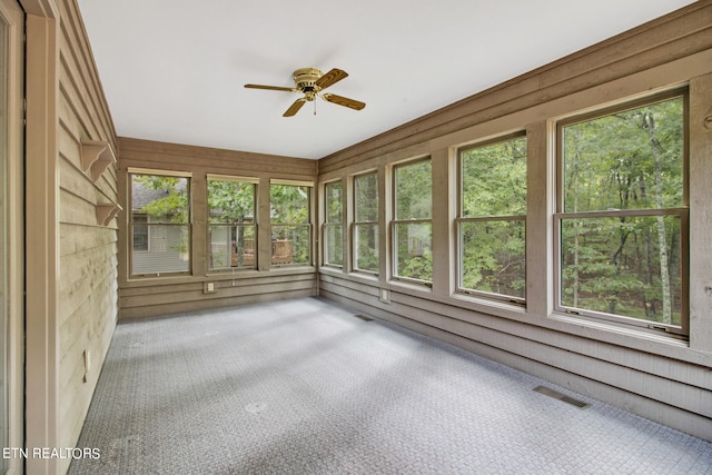 unfurnished sunroom with ceiling fan