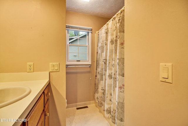 bathroom featuring a textured ceiling, tile patterned flooring, vanity, and a shower with curtain