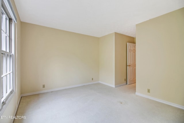 empty room with a wealth of natural light and light colored carpet