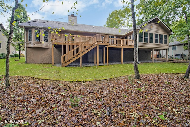 rear view of house with a deck and a yard