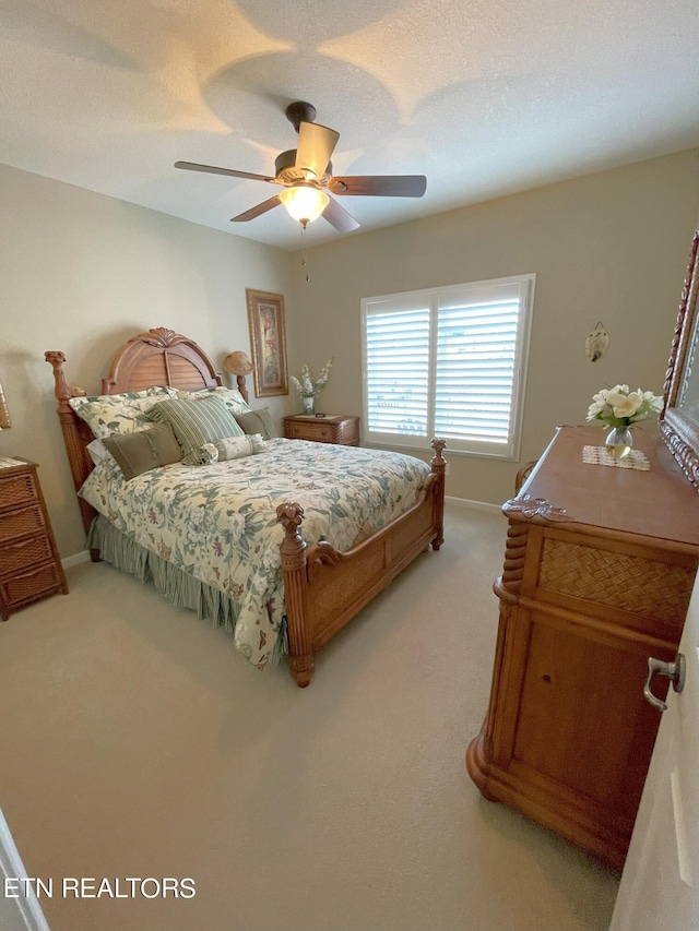 bedroom with ceiling fan, a textured ceiling, carpet, and baseboards