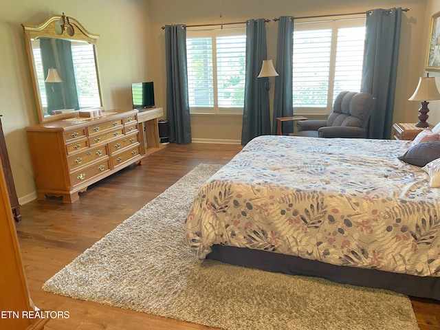 bedroom featuring baseboards and wood finished floors