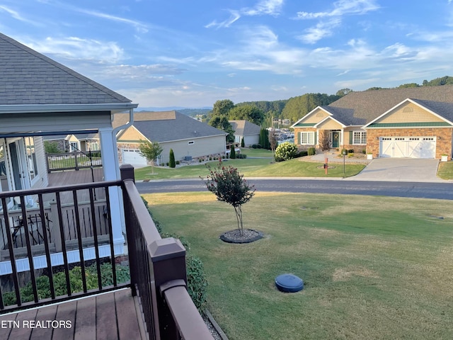 view of yard with an attached garage, driveway, and a residential view