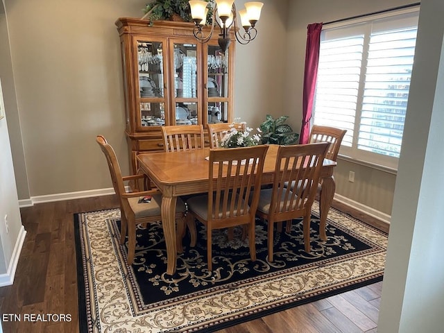 dining area with a notable chandelier, baseboards, and wood finished floors