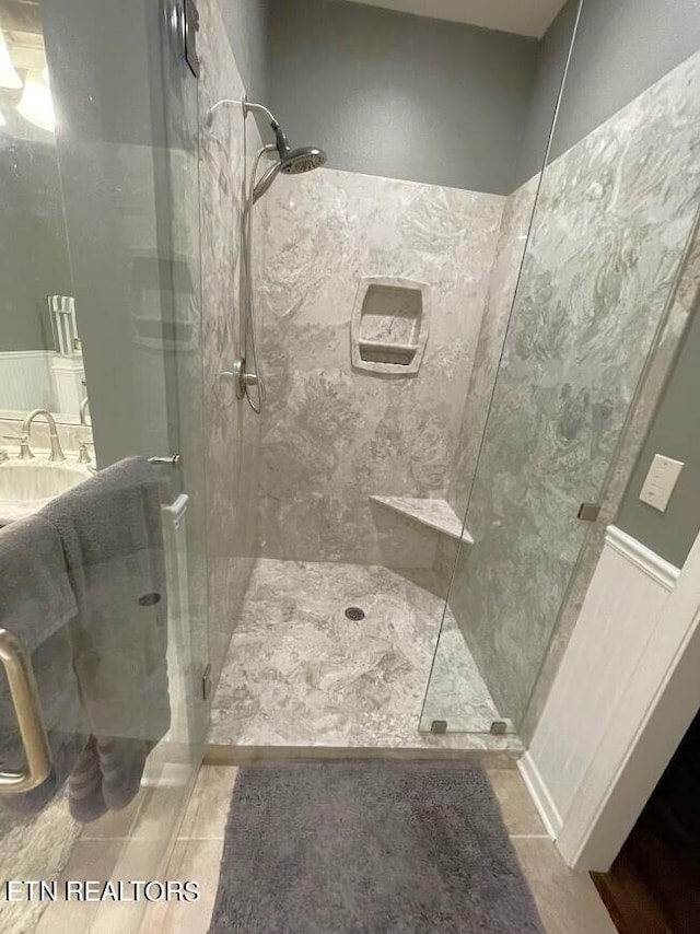 bathroom with a stall shower and tile patterned floors