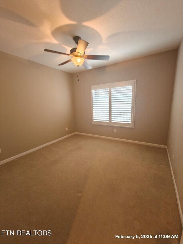 spare room featuring carpet floors, ceiling fan, and baseboards