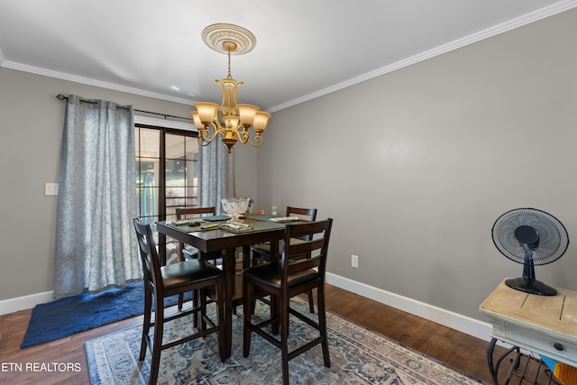 dining area featuring crown molding, hardwood / wood-style flooring, and a chandelier