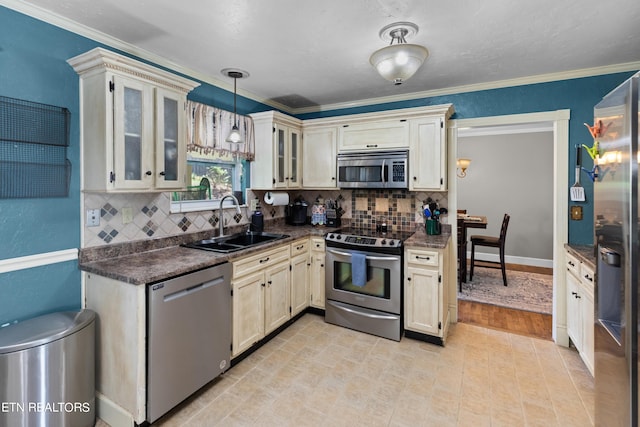 kitchen featuring appliances with stainless steel finishes, sink, decorative backsplash, and hanging light fixtures