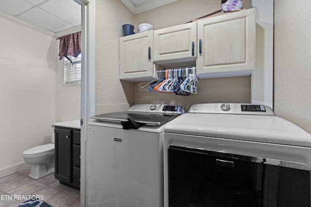 clothes washing area featuring ornamental molding, light tile patterned flooring, and washing machine and dryer