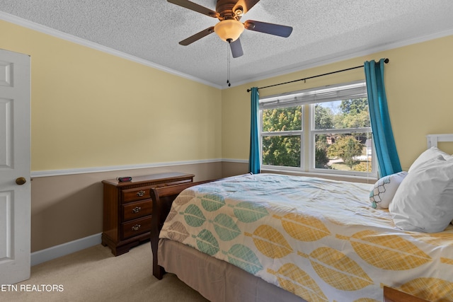 bedroom featuring ceiling fan, light carpet, a textured ceiling, and crown molding