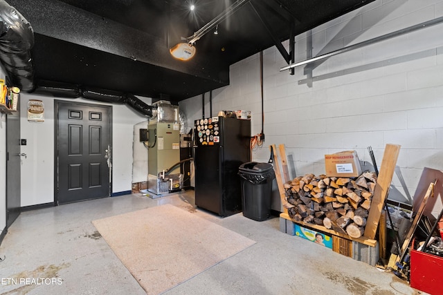 garage featuring black refrigerator and heating unit