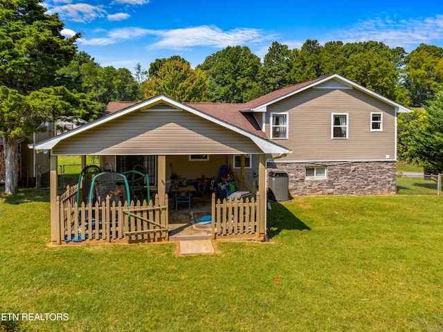 back of property featuring a yard and central air condition unit