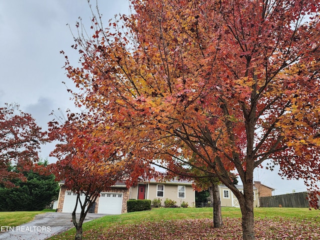 view of front of home with a garage and a front lawn