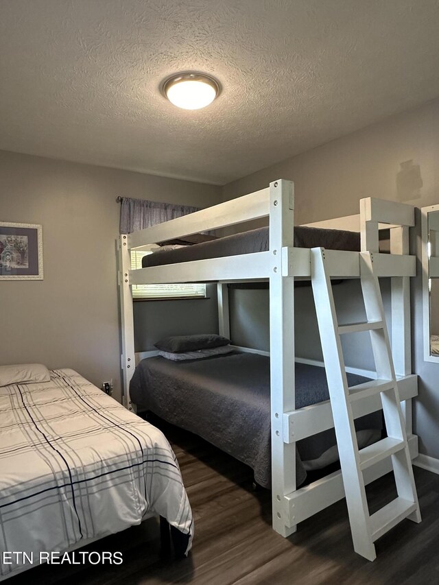 bedroom featuring a textured ceiling and dark wood-type flooring