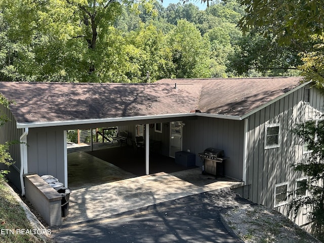 exterior space with aphalt driveway, a carport, and area for grilling