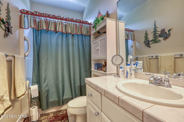 bathroom featuring vanity, toilet, a shower with curtain, and tile patterned floors