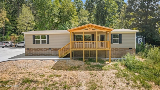 back of property with crawl space, a porch, and stairs