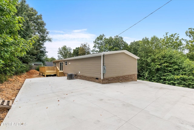 exterior space with a deck, central AC unit, a patio area, and crawl space