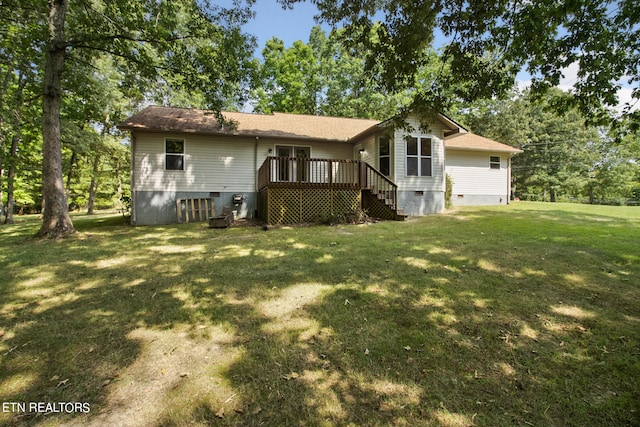 rear view of house with a yard and a deck