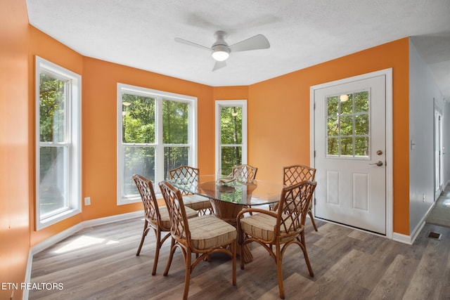 dining area featuring a textured ceiling, ceiling fan, and wood-type flooring