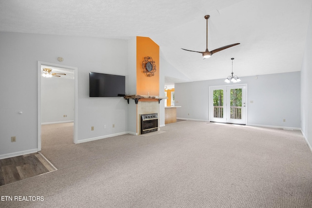 unfurnished living room with lofted ceiling, carpet, ceiling fan with notable chandelier, and a textured ceiling