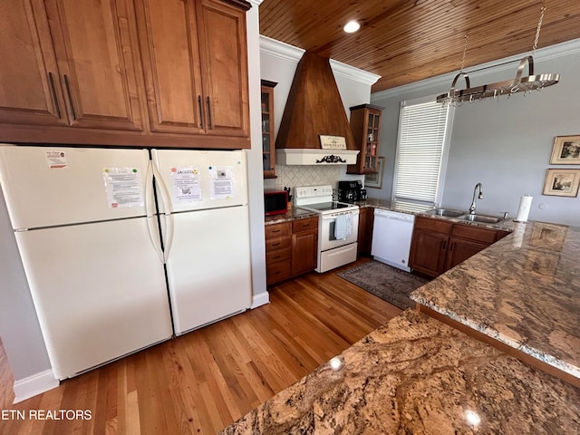 kitchen with backsplash, hardwood / wood-style flooring, crown molding, white appliances, and sink