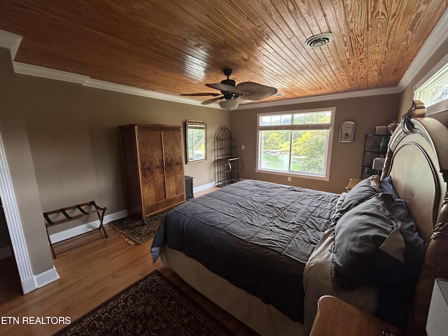 bedroom featuring wooden ceiling, wood finished floors, visible vents, baseboards, and ornamental molding