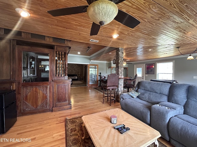 living area with light wood-type flooring, wooden ceiling, ceiling fan, and visible vents