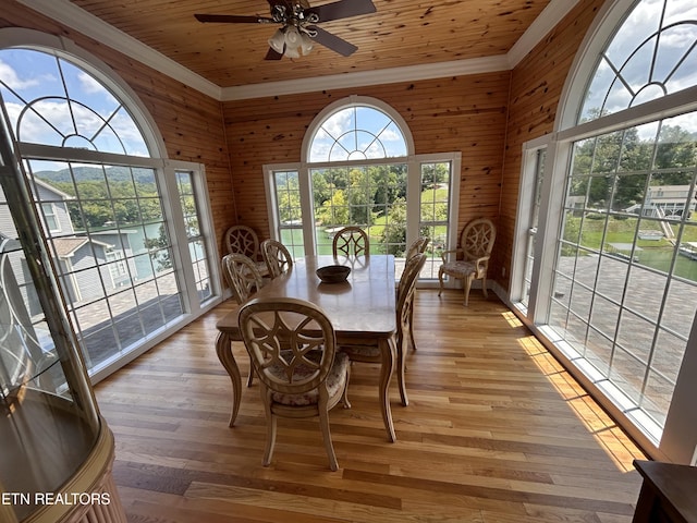 dining area with wooden ceiling, light wood-style flooring, and wooden walls