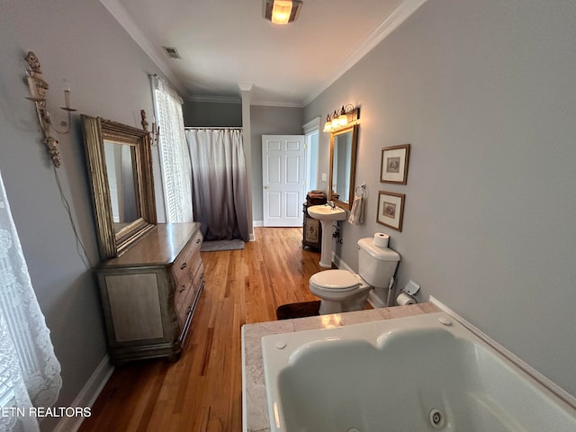 bathroom featuring toilet, ornamental molding, sink, a bath, and hardwood / wood-style flooring