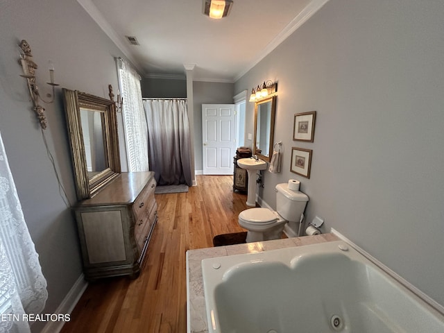 bathroom with visible vents, toilet, ornamental molding, wood finished floors, and a whirlpool tub