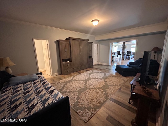 bedroom featuring light wood-type flooring and crown molding