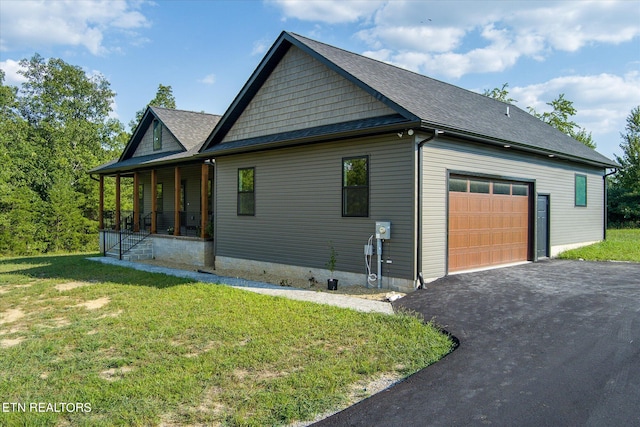 view of property exterior with a yard, covered porch, and a garage