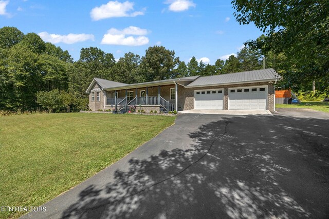 view of front of property featuring a garage, a front yard, and covered porch