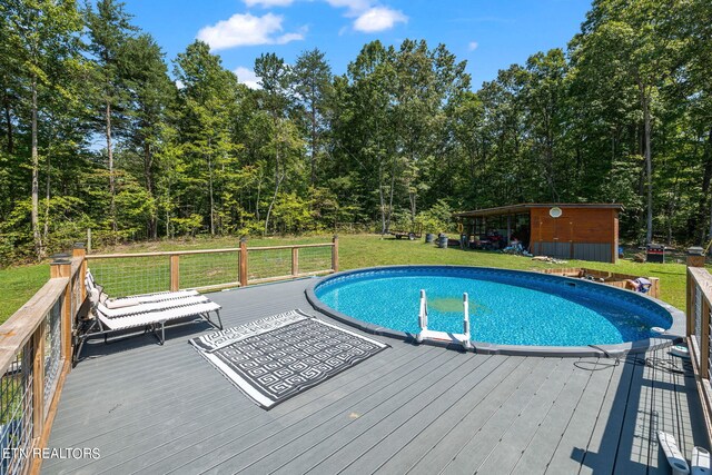 view of pool featuring a deck and a lawn