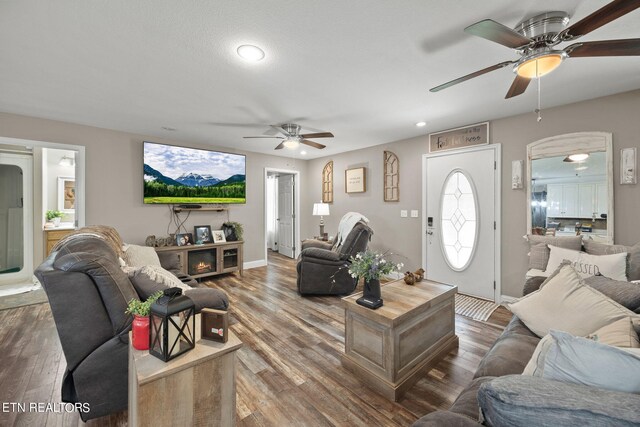 living room featuring wood-type flooring and ceiling fan